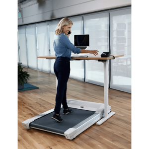 Woman walking on the Unsit treadmill whilst working at a standing desk