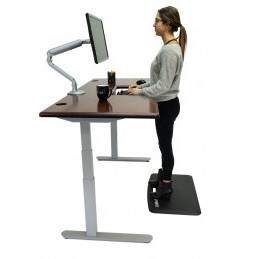 woman standing at lander desk with solid wood top and SteadyType keyboard
