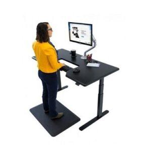 Back view of a woman standing at an iMovR Lander desk with built-in SteadyType keyboard tray