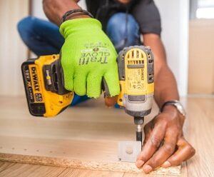Electric screwdriver attaching bracket to a sheet of MDF