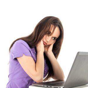 Girl sitting in front of laptop looking fed up