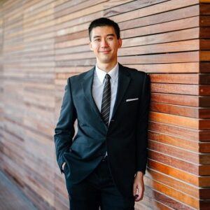 Man standing against a wall wearing a business suit