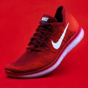 Red Nike running shoe against a red background