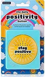 Yellow touch button reading "stay positive" in rainbow packaging