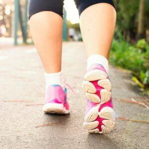 Pink, white and blue walking shoes taking a stroll on a grey pathway