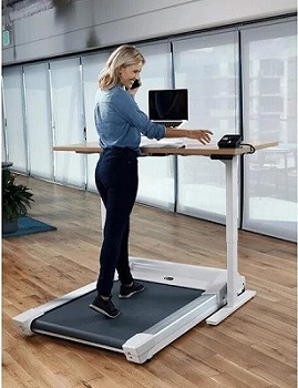 Woman walking on treadmill whilst working at standing desk