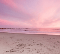 Pink and blue sky above a deserted sandy beach