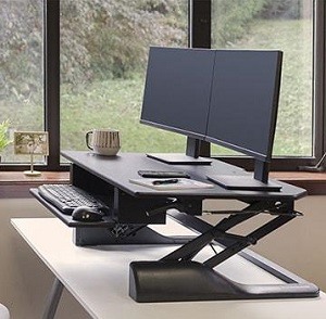 Ergotech Freedom desk converter with black frame and work tops