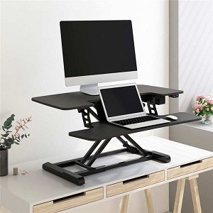 FlexiSpot electric standing desk converter with monitor and laptop