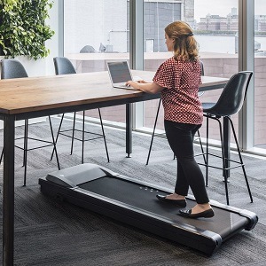 Woman working and walking on the LifeSpan Tr5000 DT3 under desk treadmill